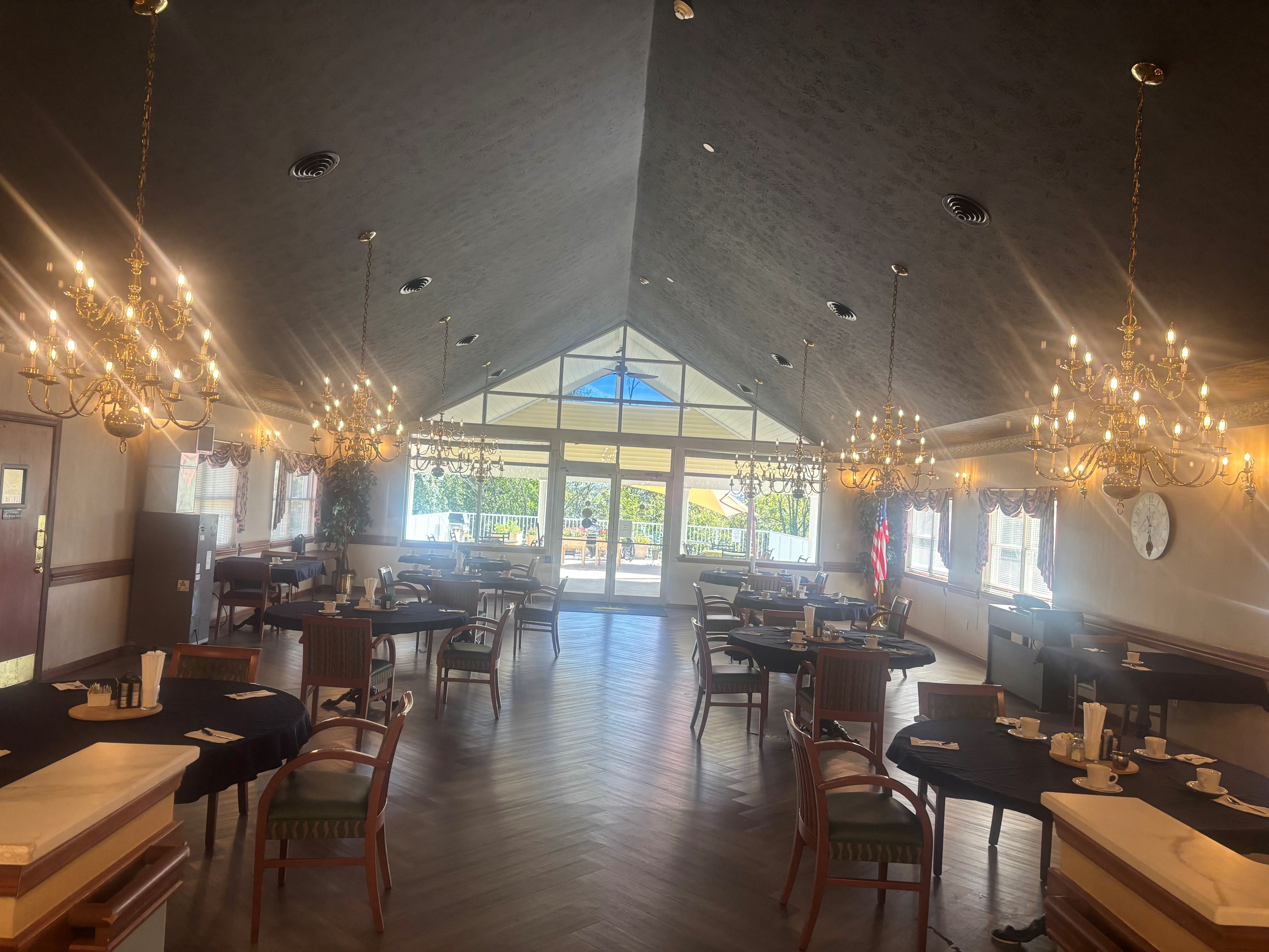 Dining room with chandeliers and large windows at Golden Heights